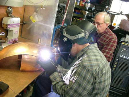 Jesse James and Fay Butler welding copper. Note the three-eyed Gargoyle: a gift from Jesse